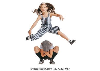 Kids games. Happy school age kids wearing retro clothes playing leapfrog isolated over white background. Concept of childhood, vintage summer fashion style. Copy space for ad