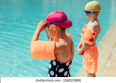 Kids getting ready for swimming lessons. Girl and boy wearing swimming gear standing by the pool. - Powered by Shutterstock