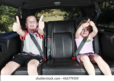 Kids Giving A Thumbs Up From The Back Of A Car