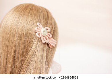 Kids' hair accessories, safe hairclips for toddlers. A soft hair clip in the hair of a blonde girl, copy space right. Hair accessory Top view