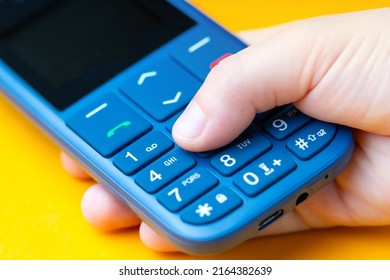 Kid's Hand Dialing Number On A Push-button Cell Phone. Macro Photography.