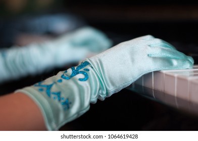 kids hand in the gloves on the piano  - Shutterstock ID 1064619428