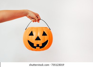 Kid's hand holding Jack'O pumpkin basket to collect candy trick or treat on Halloween day. Concept for Halloween holiday. - Powered by Shutterstock