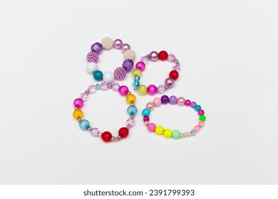 Kids handmade beaded jewelry. Necklaces and bracelets made from multicolored beads and pearls. DIY bracelet beads. Children's needlework. Creativity and hobby. Art activity for kids - Powered by Shutterstock