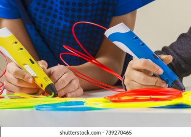 Kids Hands With 3d Printing Pen And Colorful Filaments On White Table