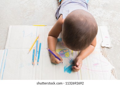 Kid's hands are drawing with colored pencils on sheet of paper. - Shutterstock ID 1132692692