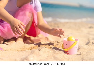 Kids Hands On Easter Egg Hunt On The Sandy Beach. Happy Easter Holidays Concept 