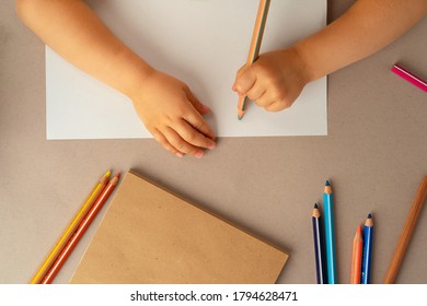 Kid's Hands Writing In Open Notebook, Top View, Copy Space