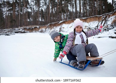 Kids have fun on the frozen lake and enjoying a sleigh ride. Winter, silence and wild nature, active winter weekend, seasonal outdoor activities, happy family lifestyle