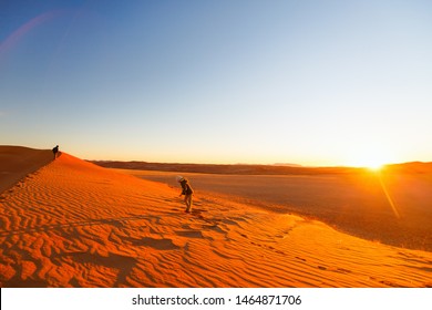 Kids Having Fun During Sunset In Red Sand Dunes In Namib Desert