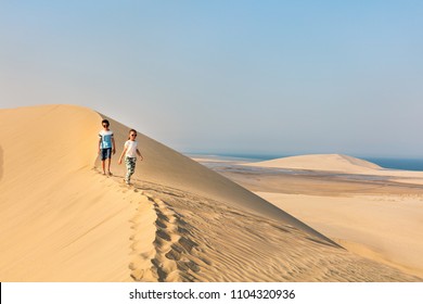 Kids Having Fun Exploring Together Sand Dunes In Qatar Desert