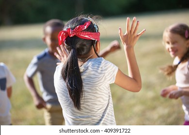 Kids having fun playing blind man's buff at the park