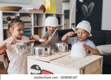 kids having fun playing on kitchen pans at home