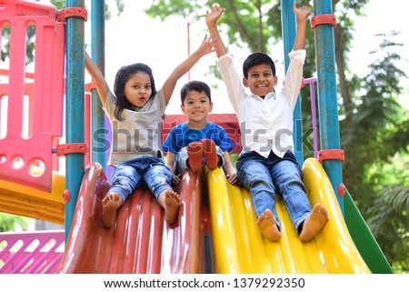 Kids having fun and sliding on outdoor playground. Kids Enjoying