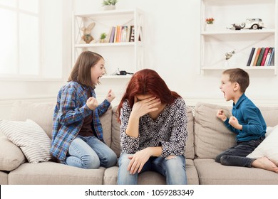 Kids having quarrel over tired mother. Mom is depressed by screaming of children. Problems of motherhood, copy space