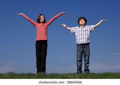 Kids Holding Arms Up Against Blue Sky