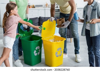 Kids holding trash near parents in latex gloves and cans with recycle sign - Powered by Shutterstock