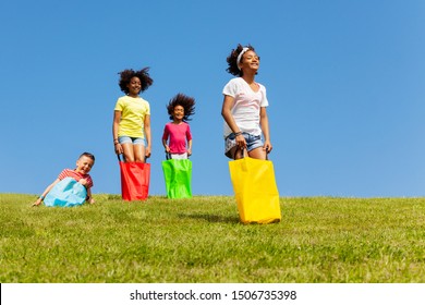 Kids hop downhill in gunny sack race game outside - Powered by Shutterstock