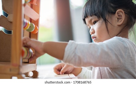 Kids Intend Learn From Play With Colorful Wooden Toy On Table Desk At Home. Preschool Young Girl Concentrating With Educational Block In Recess Term Back To School Children At Home Or Daycare Child.