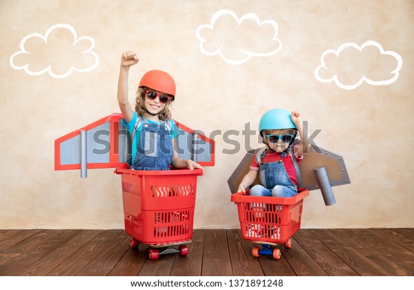 Kids with jet pack racing on shopping cart.\
Children playing at home. Success, imagination and innovation\
technology concept