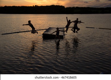 Kids Jumping Off Dock At Sunset