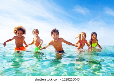 Kids laughing and playing in water at the seaside - Powered by Shutterstock