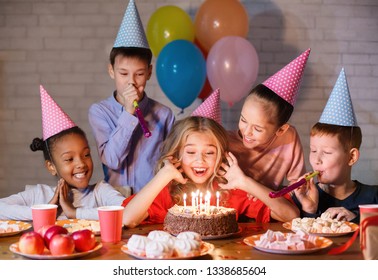 Kids looking at birthday cake with candles, having b-day party - Powered by Shutterstock