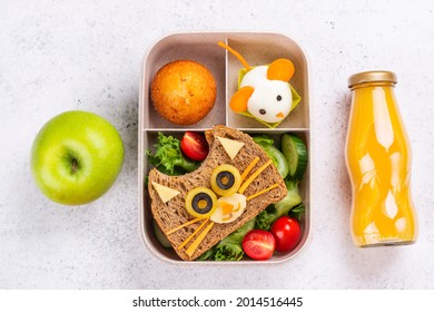 Kids lunch box with cute cat sandwich, muffin and mouse made from boiled egg. Back to school breakfast background - lunch box, bottle of orange juice and green apple. Top view. Copy space - Powered by Shutterstock