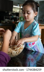 Kids Making Kek Batik Or Malaysian Triple Chocolate Dessert. Doing The Initial Steps, Crushing The Cookies Into Tiny Pieces.