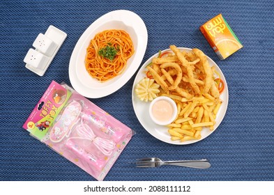 Kids Meal Crispy Chicken Tenders And French Fries On A White Plate Spaghetti In Tomato Sauce And Basil On With Toys And Salt And Pepper Soft Drink 