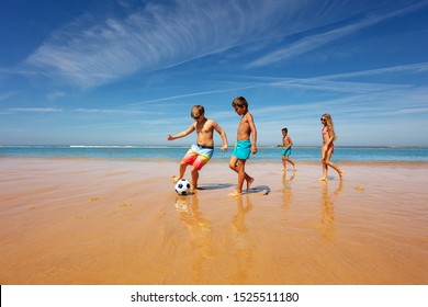 Kids in the middle of soccer game play on a beach - Powered by Shutterstock