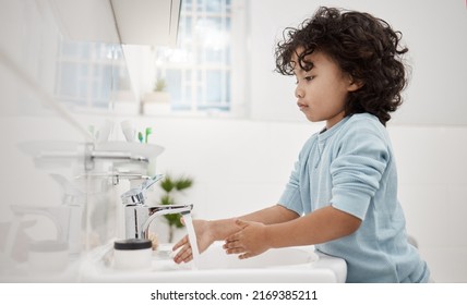 Kids Need To Keep Their Hands Clean. Shot Of An Adorable Little Boy Washing His Hands At A Tap In A Bathroom At Home.