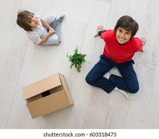 Kids In New Home Moving On Floor Top View