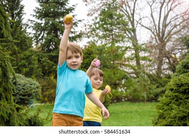 Kids On Easter Egg Hunt In Blooming Spring Garden. 