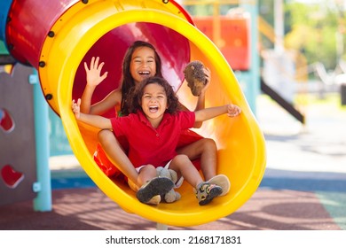Kids on playground. Children play outdoor on school yard slide. Healthy activity. Summer vacation fun. Child playing in sunny park. Kid having fun on colorful slide. - Shutterstock ID 2168171831
