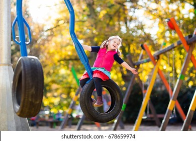 Kids On Playground Children Play In Park. Child On Slide And Swing On Sunny Fall Day. Preschool Or Kindergarten Yard.