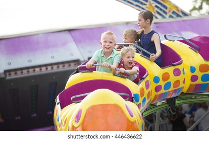 Kids On A Thrilling Roller Coaster Ride At An Amusement Park 