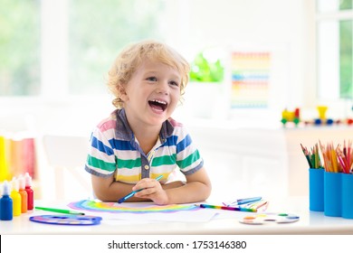 Kids Paint. Child Painting In White Sunny Study Room. Little Boy Drawing Rainbow. School Kid Doing Art Homework. Arts And Crafts For Kids. Paint On Children Hands. Creative Little Artist At Work.