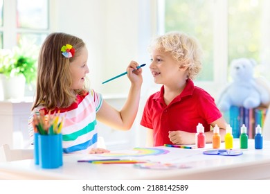 Kids paint. Child painting in white sunny study room. Little boy and girl drawing rainbow. School kid art homework. Arts and crafts for kids. Paint on children hands. Creative little artist at work.