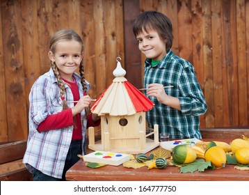Kids Painting The Bird House Preparing For Winter - Environmental Awareness Concept