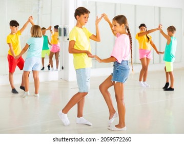 Kids In Pairs Exercising Salsa Moves Together During Group Dance Class.