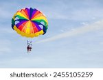 Kids parasailing. Water sport on summer vacation. Brother and sister flying in tropical ocean resort. Sea and beach fun. Rainbow parachute. Teenage boy and little girl fly.