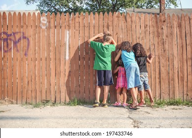 Kids peeking through a fence