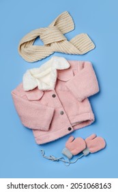 Kids pink fur jacket  with scarf  on blue background. Stylish childrens outerwear. Winter fashion outfit 