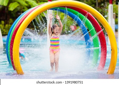 Kids Play In Aqua Park. Children At Water Playground Of Tropical Amusement Park. Little Girl At Swimming Pool. Child Playing At Water Slide On Summer Vacation In Asia. Swim Wear For Young Kid.