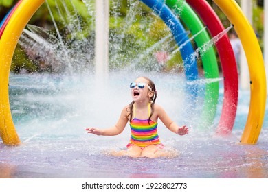Kids play in aqua park. Children at water playground of tropical amusement park. Little girl at swimming pool. Child playing at water slide on summer vacation in Asia. Swim wear for young kid.