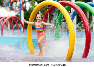 Kids Play In Aqua Park. Children At Water Playground Of Tropical Amusement Park. Little Girl At Swimming Pool. Child Playing At Water Slide On Summer Vacation In Asia. Swim Wear For Young Kid.