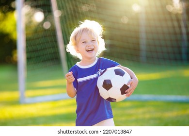 Kids play football on outdoor field. France team fans with national flag. Children score a goal at soccer game. Child in French jersey and cleats kicking ball. Fan celebrating victory at pitch. - Powered by Shutterstock