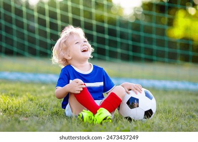 Kids play football on outdoor field. France team fans with national flag. Children score a goal at soccer game. Child in French jersey and cleats kicking ball. Fan celebrating victory at pitch. - Powered by Shutterstock