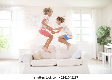 Kids Play At Home. Children Jump, Run And Dance. Active Boys Playing Tag, Running And Jumping On Couch In White Sunny House. Family Indoor Fun. Boy In Living Room. Activity And Movement Indoors.